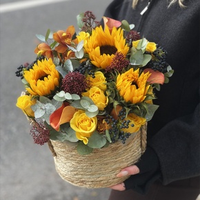 Композиция в сумке "Тональность" из подсолнухов, калл, ягод вибирнума, лимонных роз, скиммии и орхидеи в Ногинске
