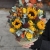 Композиция в сумке "Тональность" из подсолнухов, калл, ягод вибирнума, лимонных роз, скиммии и орхидеи в Ногинске
